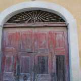 Ci avviciniamo all�entrata: un grande portone in legno inserito in un arco a tutto sesto ribassato...